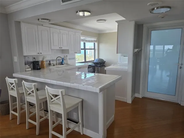 a kitchen with granite countertop a sink cabinets and refrigerator