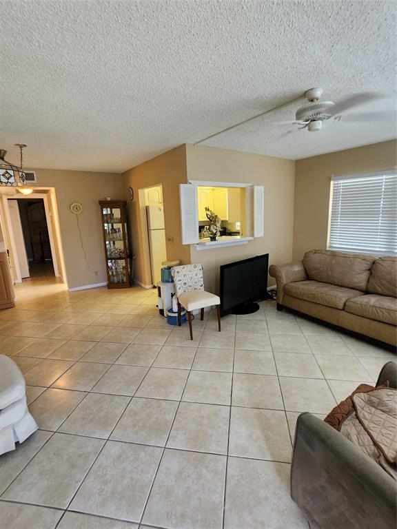 104 Westbury East, Unit 104 Deerfield Beach, FL 33442 - Photo 1 of 40 a living room with furniture and a flat screen tv