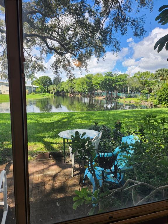 104 Westbury East, Unit 104 Deerfield Beach, FL 33442 - Photo 22 of 40 a view of a lake with a yard table and chairs
