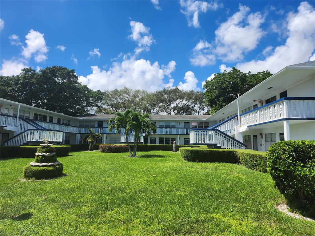 104 Westbury East, Unit 104 Deerfield Beach, FL 33442 - Photo 24 of 40 a view of a house with a patio and a yard