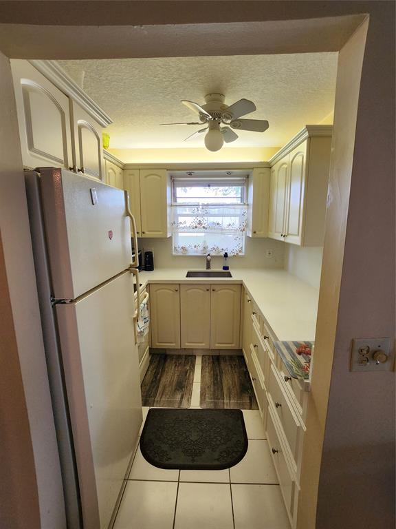 104 Westbury East, Unit 104 Deerfield Beach, FL 33442 - Photo 8 of 40 a kitchen with a refrigerator a sink and a stove