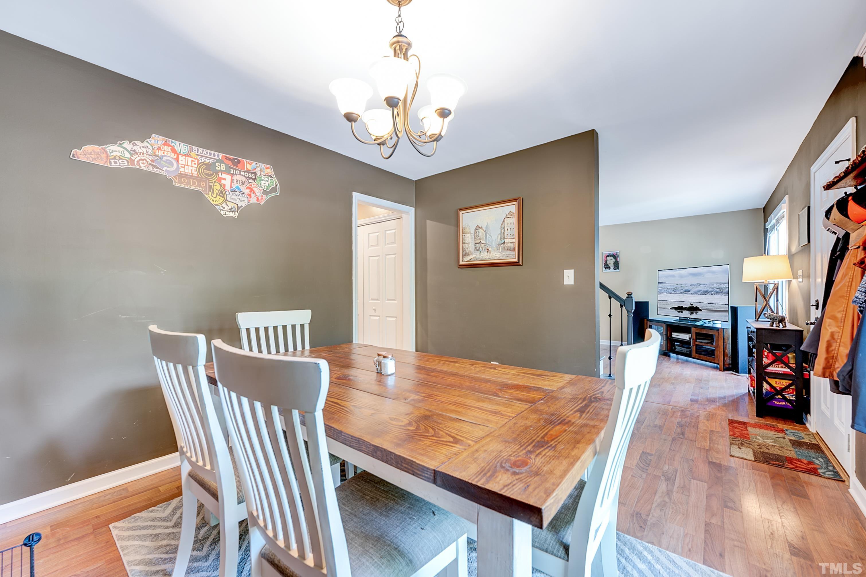 5109 Antler Ridge Court Raleigh, NC 27616 - Photo 17 of 30 a view of a dining room with furniture a chandelier and wooden floor