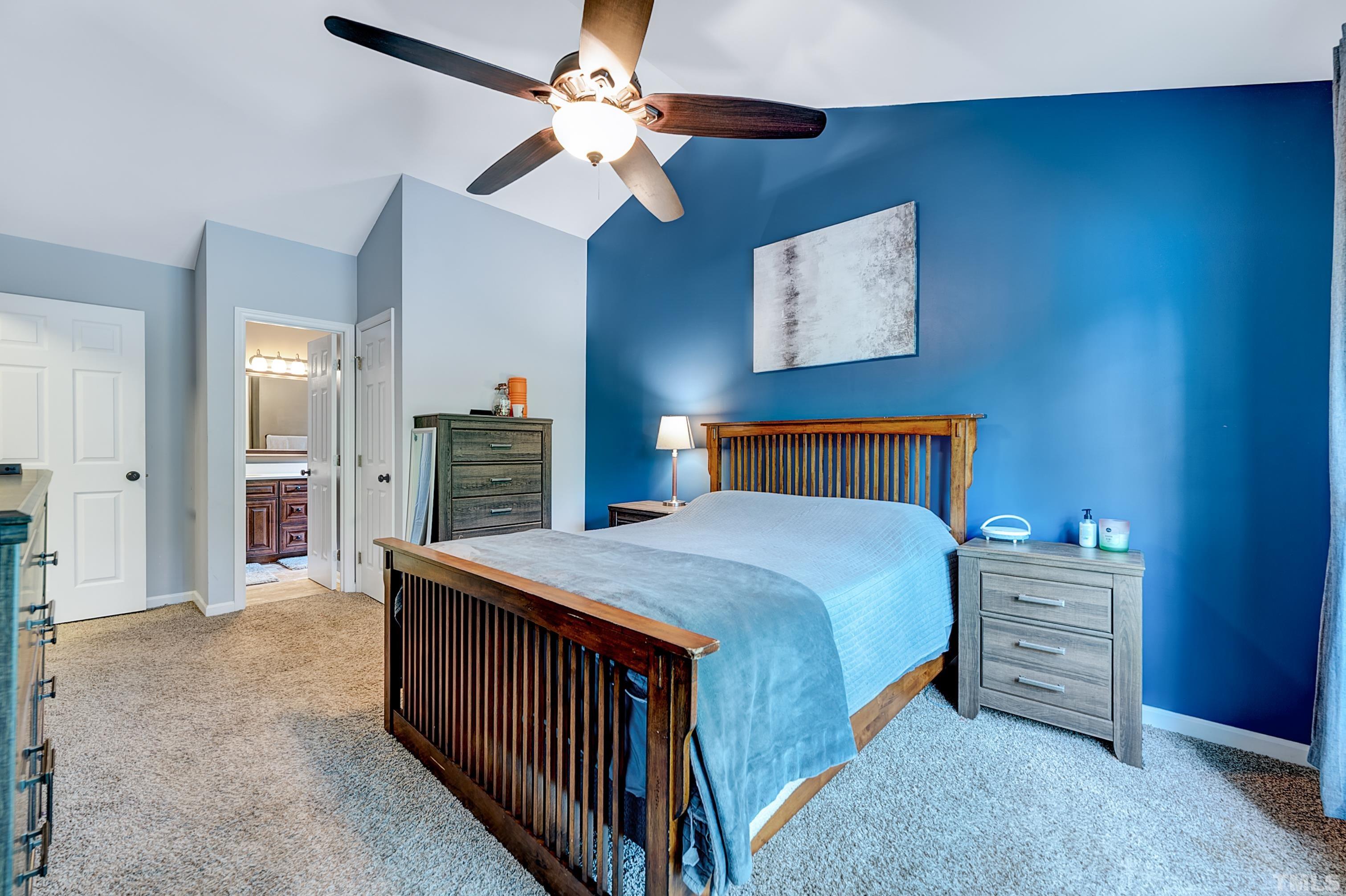 5109 Antler Ridge Court Raleigh, NC 27616 - Photo 23 of 30 a bedroom with a bed a chandelier and a dresser