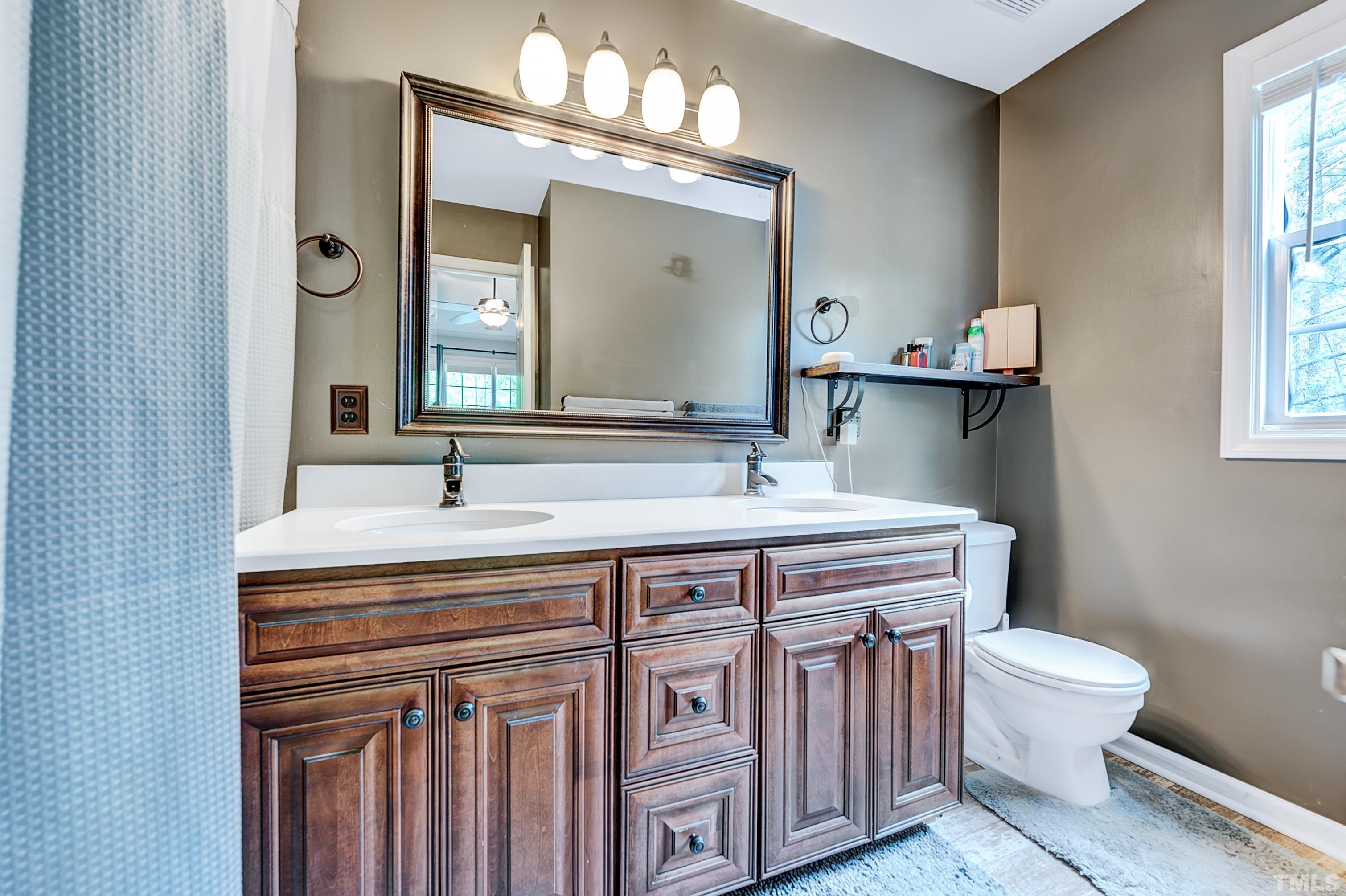 5109 Antler Ridge Court Raleigh, NC 27616 - Photo 26 of 30 a bathroom with a sink a toilet and a mirror