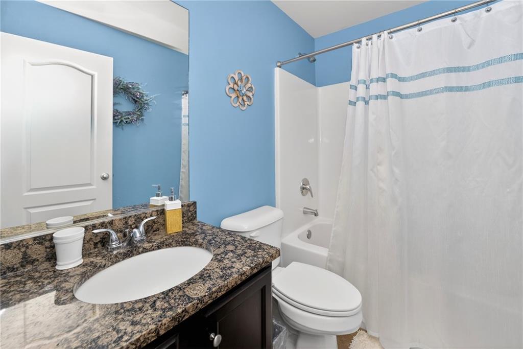 2300 Tucker Mill Road Southwest Conyers, GA 30094 - Photo 32 of 45 a bathroom with a granite countertop sink toilet and a mirror