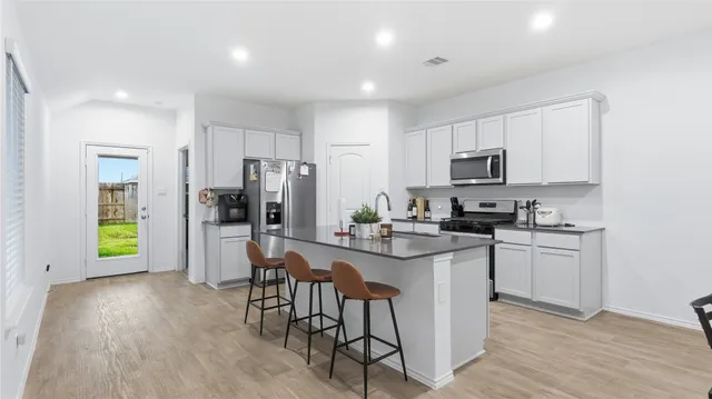 a kitchen with a sink a microwave a refrigerator and cabinets