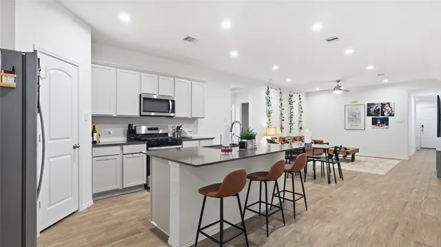 a kitchen with appliances cabinets and a dining table