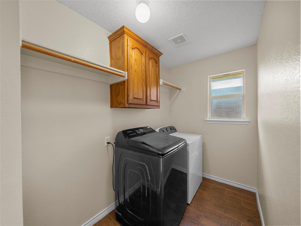 741 Aspen Court Allen, TX 75002 - Photo 20 of 40 Laundry area with cabinet space, dark wood-style floors, a textured ceiling, washing machine and clothes dryer