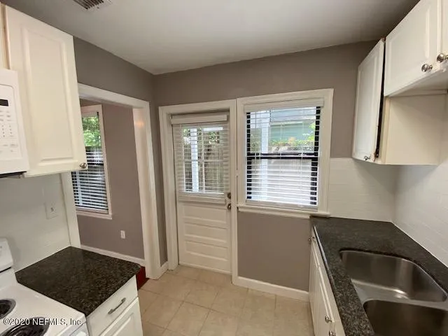 a kitchen with a sink a stove and cabinets