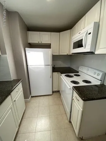 a kitchen with a stove a microwave and a refrigerator