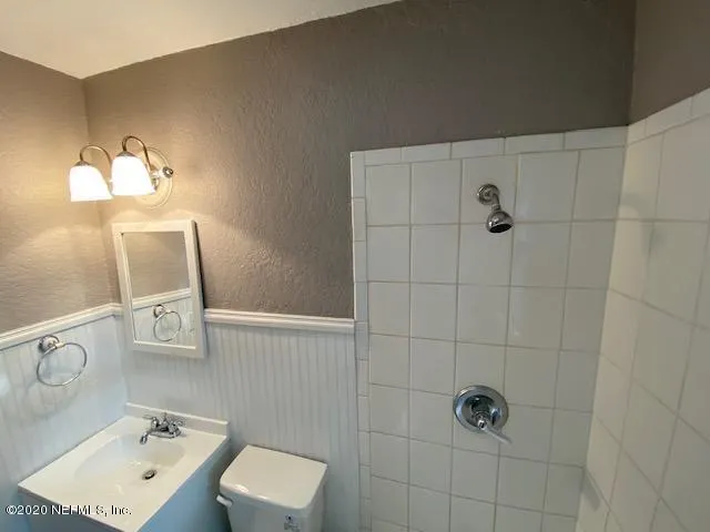 a bathroom with a sink mirror and toilet