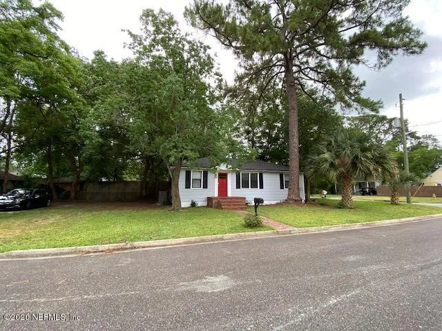 a front view of a house with a yard and trees