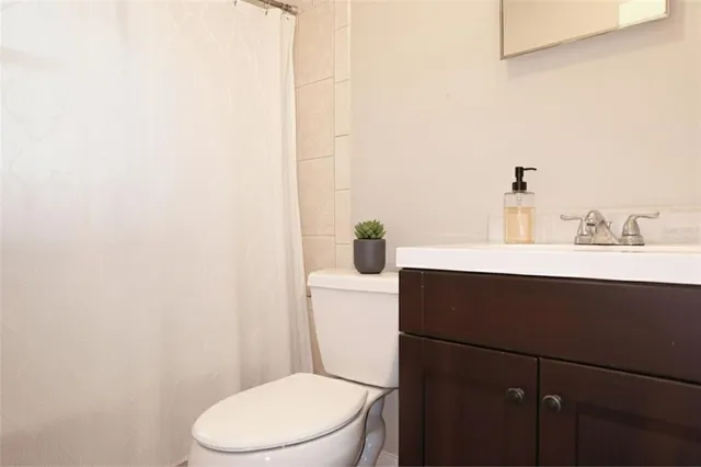 a bathroom with a sink vanity mirror and toilet