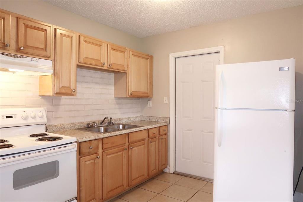 4109 West Arch Street Tampa, FL 33607 - Photo 10 of 14 a kitchen with a sink a stove a refrigerator and cabinets