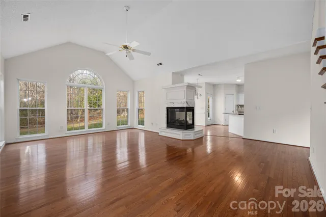 a view of empty room with wooden floor and fireplace