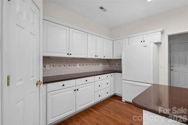a kitchen with granite countertop white cabinets and white appliances