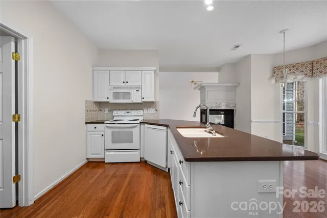 a kitchen with granite countertop a sink stove and refrigerator