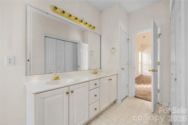 a en suite bathroom with a granite countertop sink and a mirror