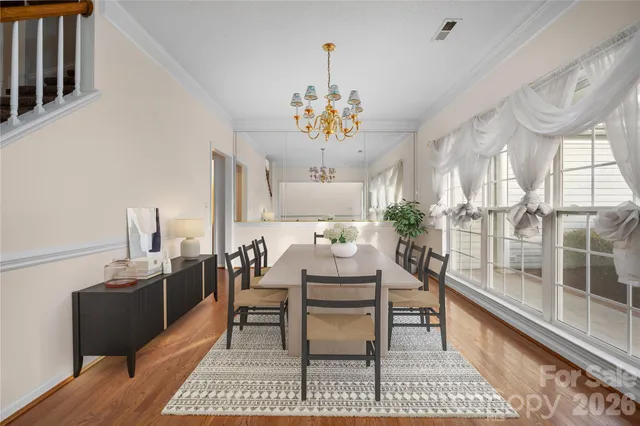a view of a dining room with furniture a chandelier and wooden floor