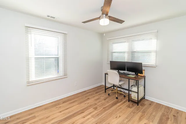 a workspace with wooden floor and a window