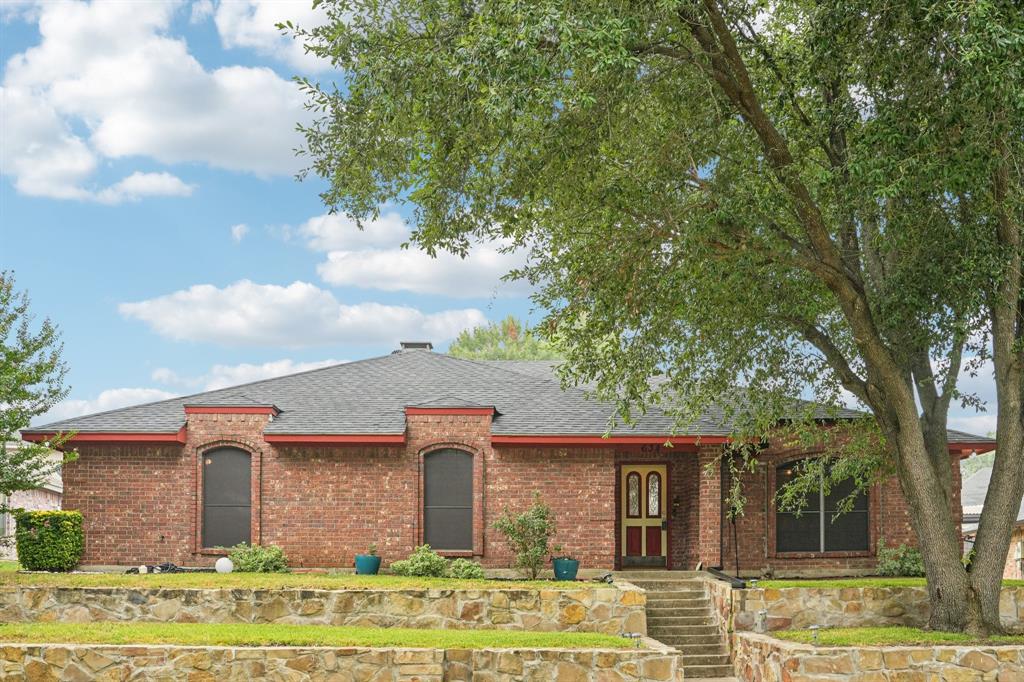 View of front of home featuring a shingled roof and brick siding