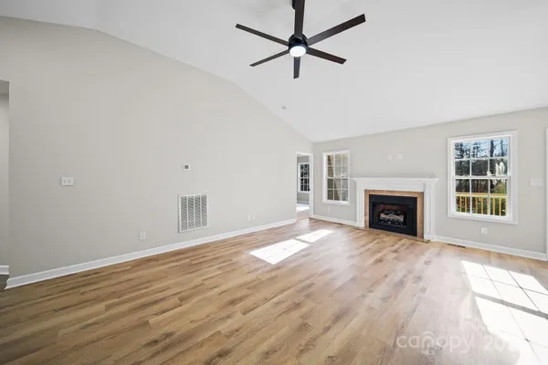 wooden floor fireplace and windows in an empty room