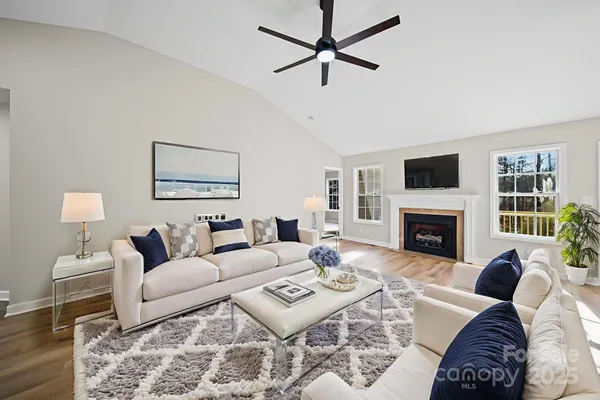 a living room with furniture a fireplace and a flat screen tv
