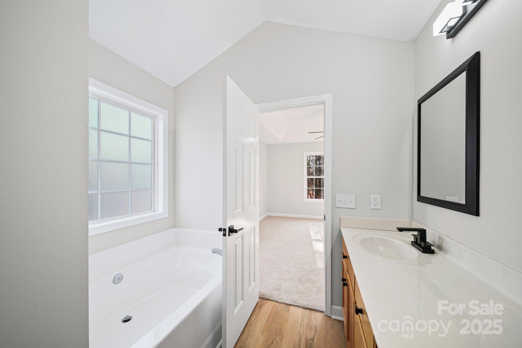 1562 Piney Church Road Concord, NC 28025 - Photo 25 of 40 a bathroom with a tub sink and mirror
