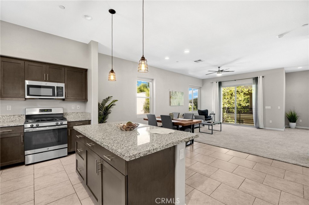 746 Farrier Way Upland, CA 91786 - Photo 12 of 45 a kitchen with a stove a sink a counter space and living room view