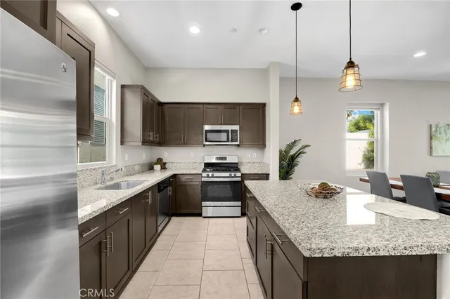 a kitchen with stainless steel appliances granite countertop a sink a stove top oven a counter space and cabinets