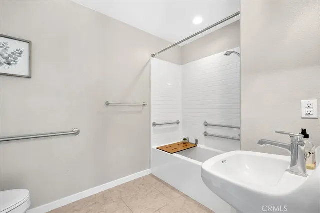 a bathroom with a sink a toilet a shower and a mirror