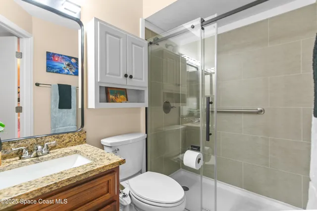 a bathroom with a granite countertop toilet sink and shower