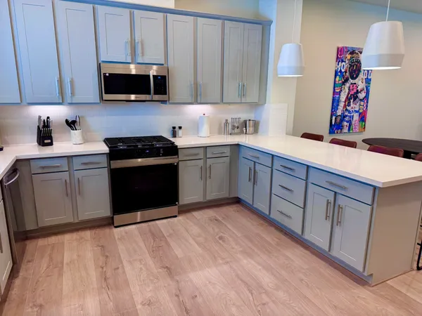 a kitchen with stainless steel appliances granite countertop a sink stove and microwave