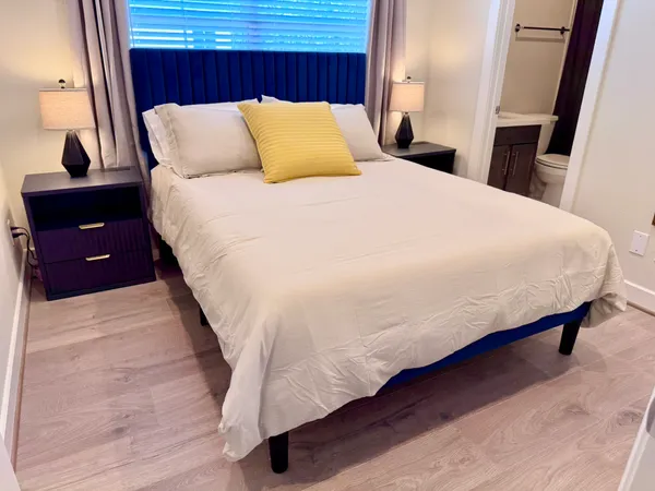 a bedroom with a bed and a painting on the wall