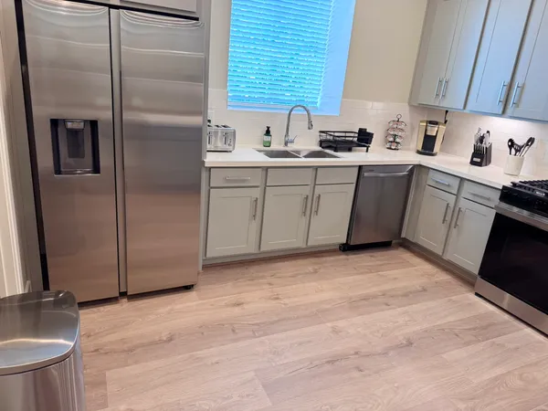 a kitchen with stainless steel appliances a sink a stove a refrigerator and cabinets