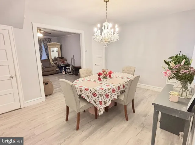 a dining room with furniture a chandelier and wooden floor