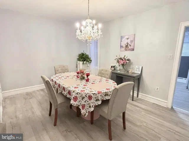 a dining room with furniture a chandelier and wooden floor