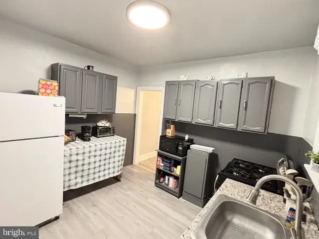 a kitchen with a refrigerator and a stove top oven