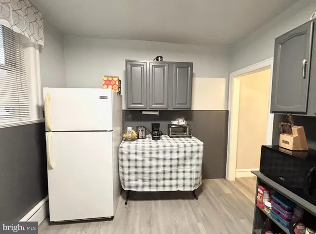 a kitchen with a refrigerator and a stove top oven
