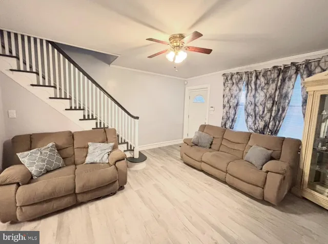a living room with furniture and a ceiling fan