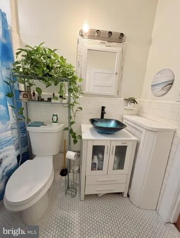 a bathroom with a toilet a sink and a mirror