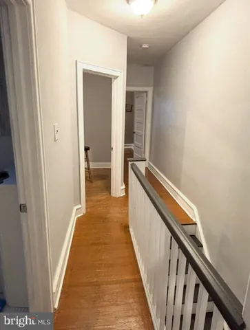 a view of a hallway with wooden floor and staircase