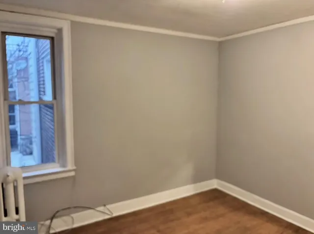 a view of a small space with wooden floor and a window