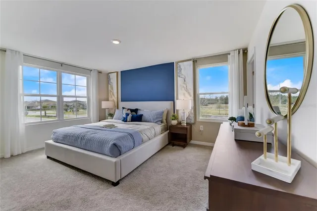 a spacious bedroom with a bed a couch and large window