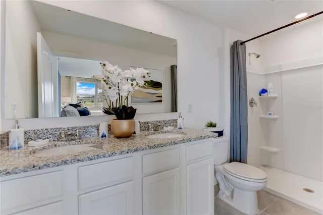 a bathroom with a granite countertop sink a toilet and a mirror