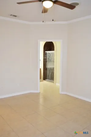 a view of an empty room with window and chandelier fan