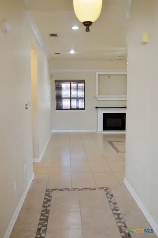 an empty room with a windows and ceiling fan
