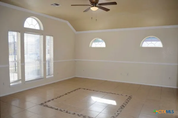 a view of an empty room with window and fireplace