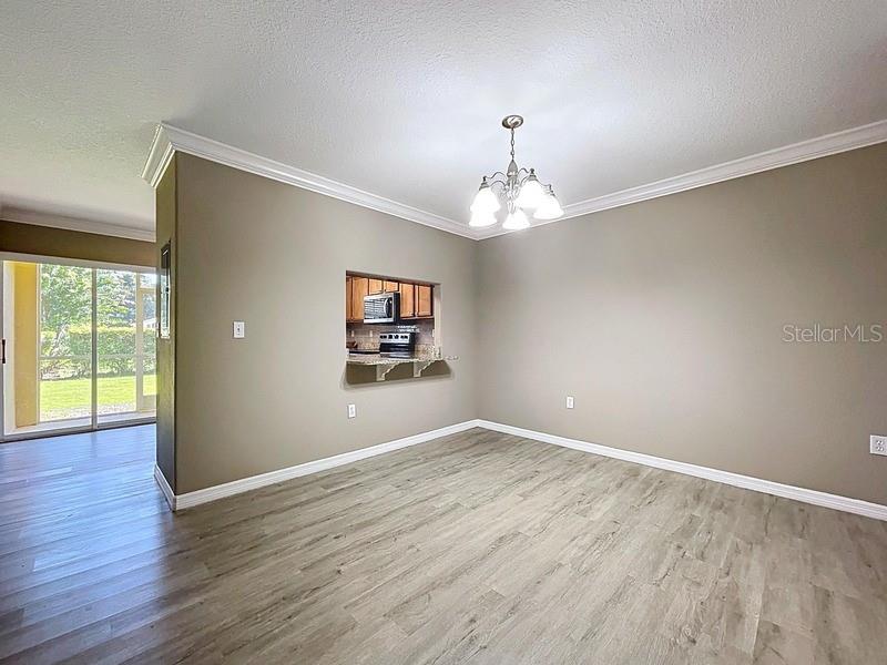 37615 Daliha Terrace Zephyrhills, FL 33542 - Photo 3 of 16 an empty room with wooden floor chandelier and windows