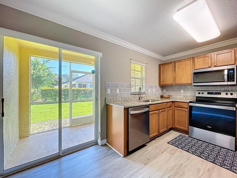 37615 Daliha Terrace Zephyrhills, FL 33542 - Photo 4 of 16 a kitchen with stainless steel appliances granite countertop a stove a sink and a microwave